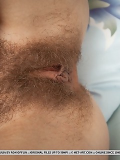 Ulia curly-haired ulia spreads her legs wide open on the bed baring her unshaven pussy and   slender body.