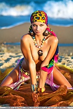 Colorful, vibrant, and enchanting model evoking a sexy sea gypsy by the beach.
